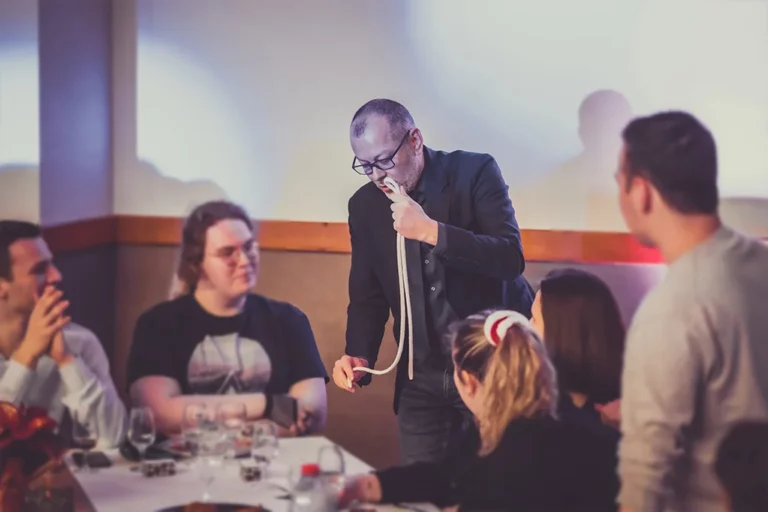 Lioz magicien à Metz réalisant un tour avec une corde à une table