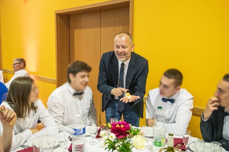 Lioz magicien à Metz réalisant un tour de magie à une table devant 2 jeunes hommes concentrés.